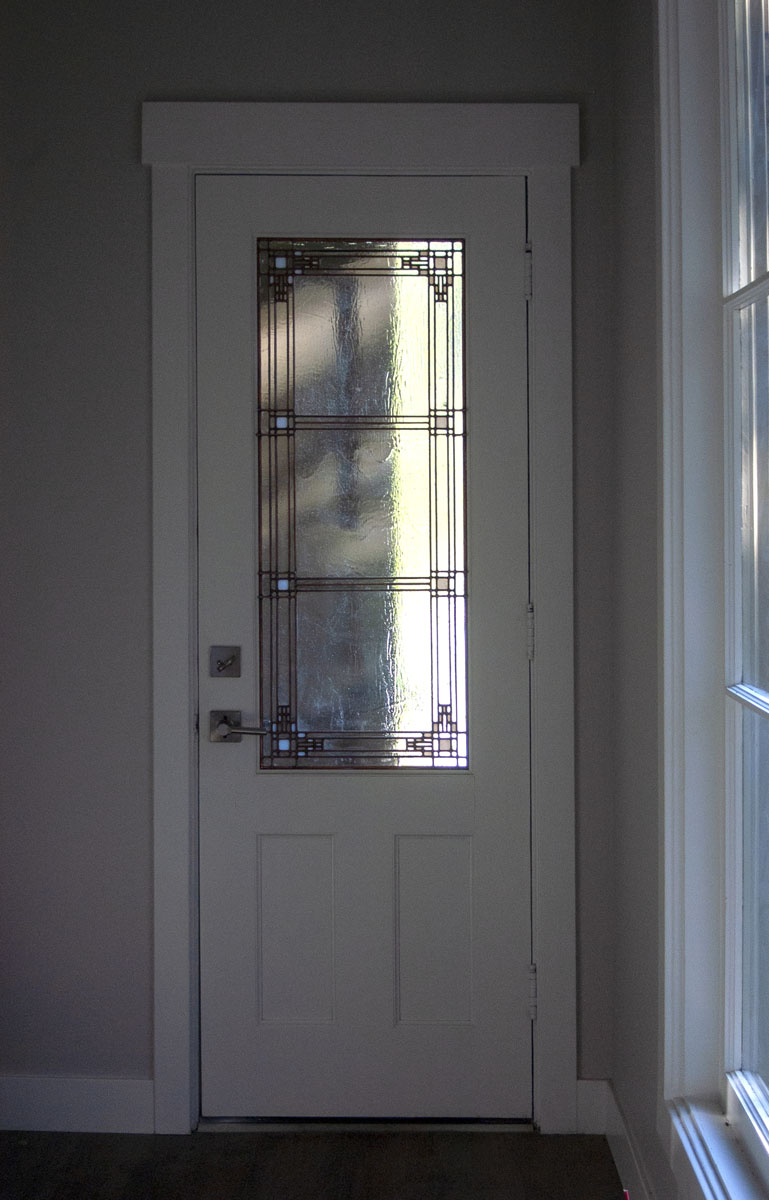 Ashton also created leaded glass for the back door (shown here) and a smaller panel for the door to ...