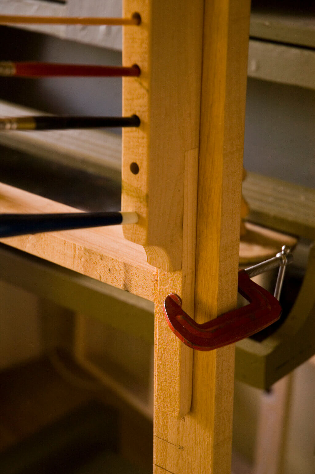 The extension at the bottom of the holder is clamped to the panel-support framework.