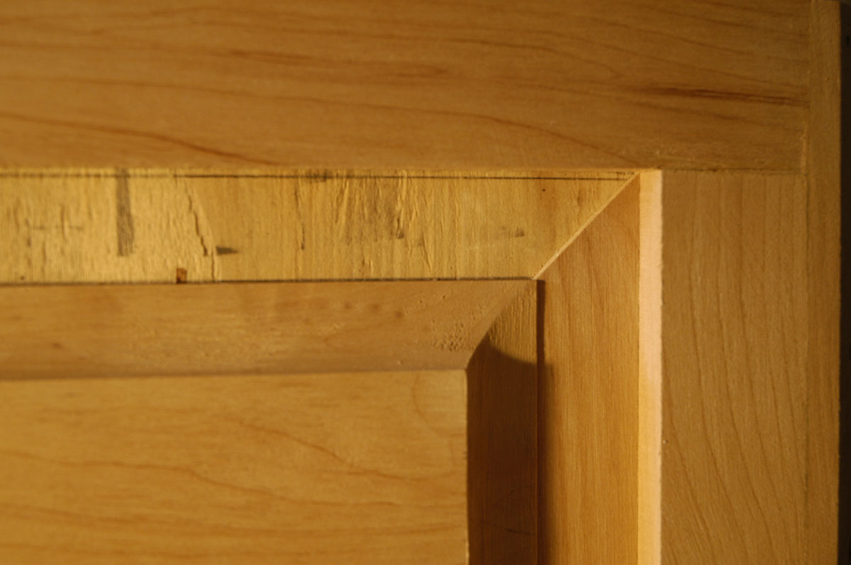 Exposed plywood (the exterior surface of the plywood box) is visible between the raised-panel elemen...